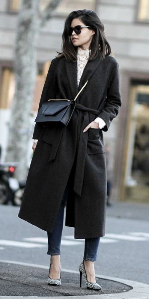 black walker coat with gray knitted sweater with stand-up collar and ankle jeans
