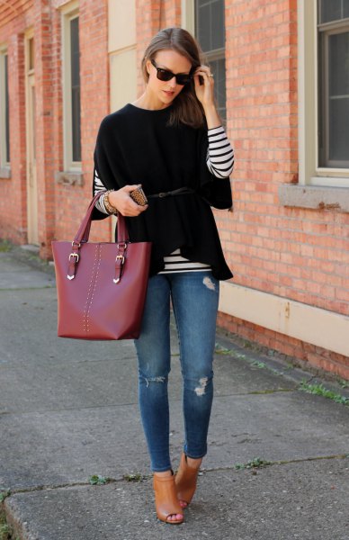 black wide-sleeved sweater over a striped long-sleeved T-shirt