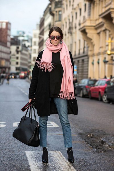 black wool coat with a light pink fringed scarf and black, narrow-cut jeans