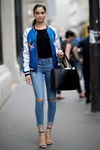 blue and white embroidered bomber jacket with black t-shirt and ripped jeans