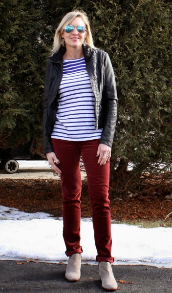 blue and white striped t-shirt with black moto jacket and brown trousers