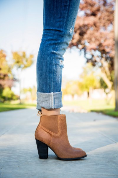 blue jeans with cuffs and brown leather boots with ankle heel