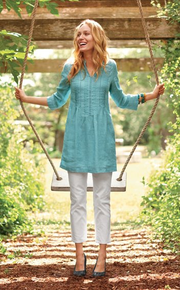 blue tunic top with three-quarter sleeves and gathered waist and white, cropped trousers