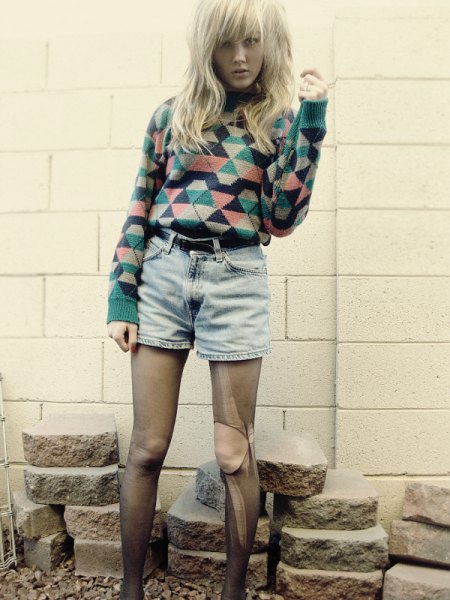 blushing and black diamond-printed sweater with high-waisted denim shorts with a belt