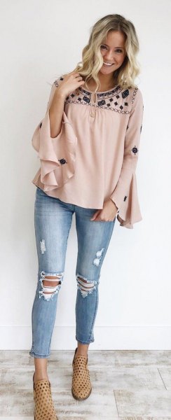 blushing and black blouse with wide ruffle sleeves and ripped and shortened jeans