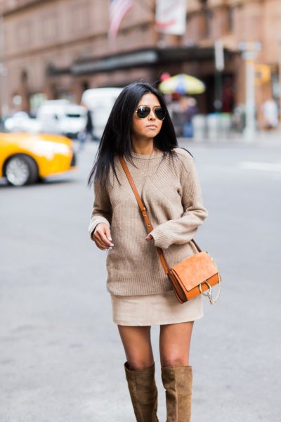 Blushing pink chunky knit sweater with mini ivory skirt and brown suede bag