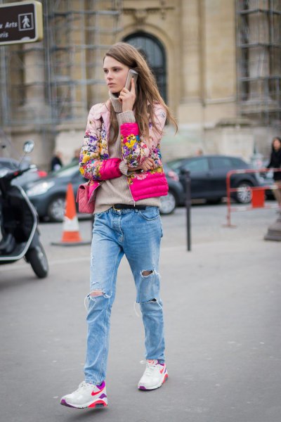 blushing pink floral print bomber jacket with boyfriend jeans and white trail shoes