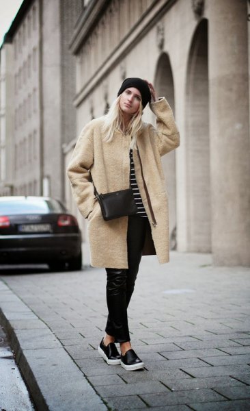 Blush pink long woolen coat with black leather pants and slip-on canvas shoes