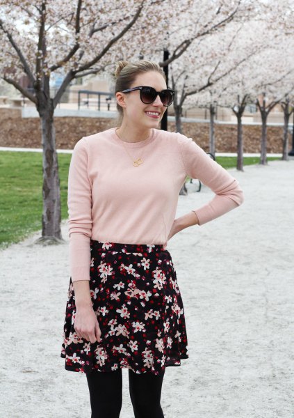 Blushing pink sweater with a black and white mini skirt with a floral pattern