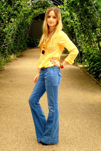 bright yellow long-sleeved blouse with blue flared jeans