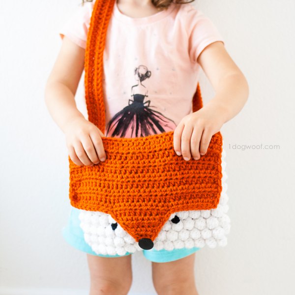 Knit shoulder bag in a brown and white fox shape with a light yellow t-shirt