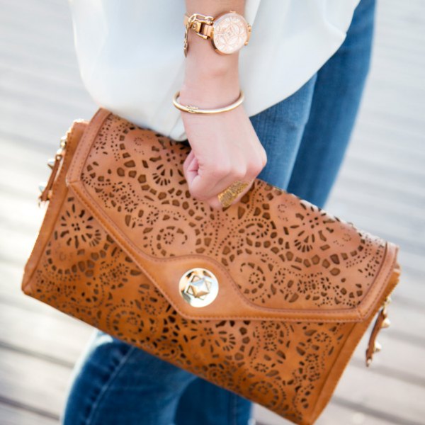 brown neckline clutch made of soft leather with white chiffon blouse and blue jeans
