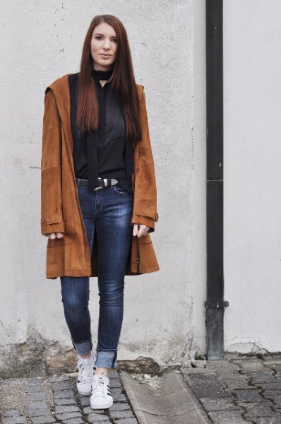 brown suede coat with black blouse with choker neckline and jeans with cuffs