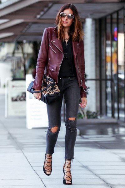 burgundy-colored faux leather jacket with dark ripped skinny jeans