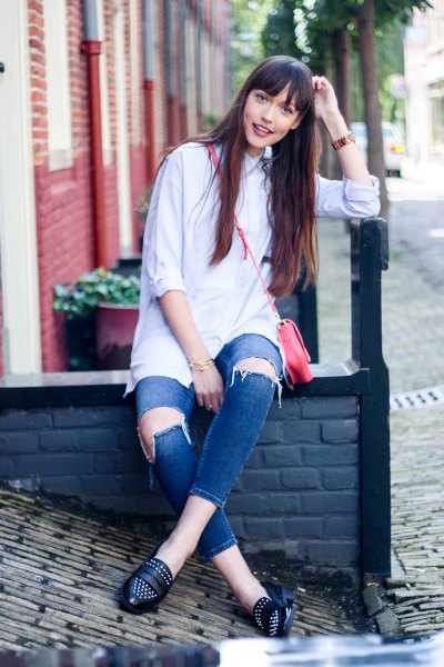 Button-up shirt with heavily ripped blue jeans