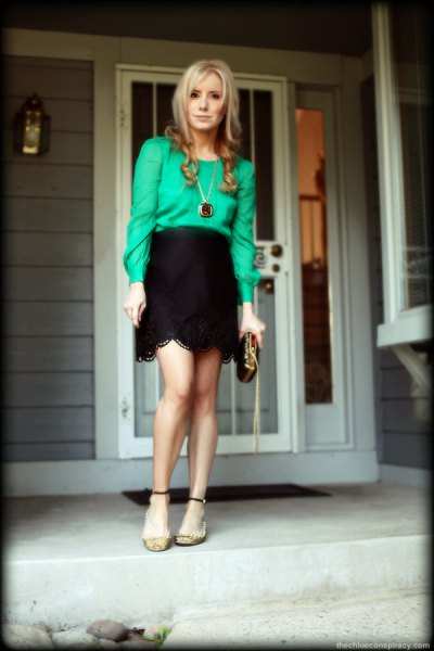 Buttonless blouse with a black, high-waisted miniskirt with a scalloped edge