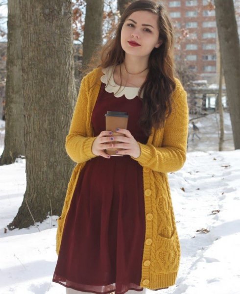 Long cable-knitted sweater with a burgundy chiffon mini dress