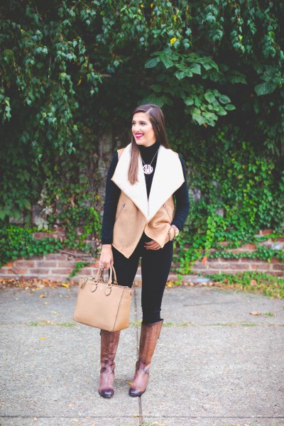 Camel and white lambskin vest with black skinny jeans and knee-high boots