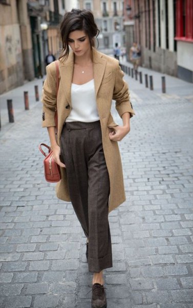 Camel longline wool coat with white silk top and gray trousers with wide legs