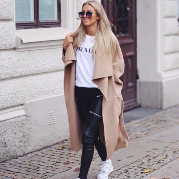 Winter coat in camel taxi length with white printed T-shirt and black leather pants