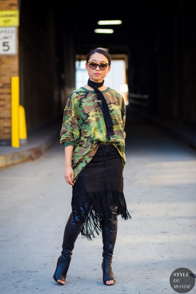 Oversized camo sweater with knee-high boots in black leather with an open toe