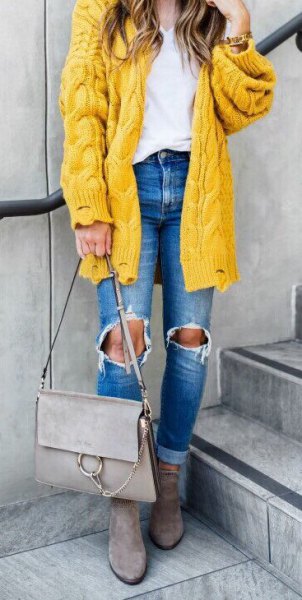 coarse cable knit cardigan with ripped blue jeans