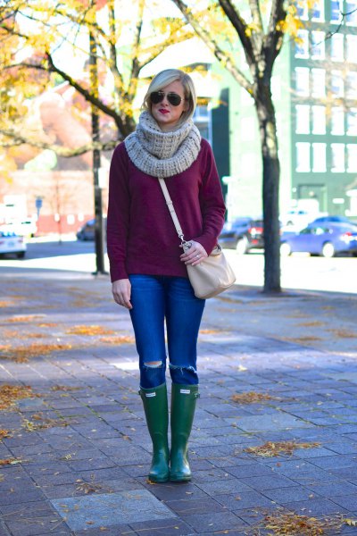 Coarsely knitted sweater with a gray scarf and knee-high leather boots