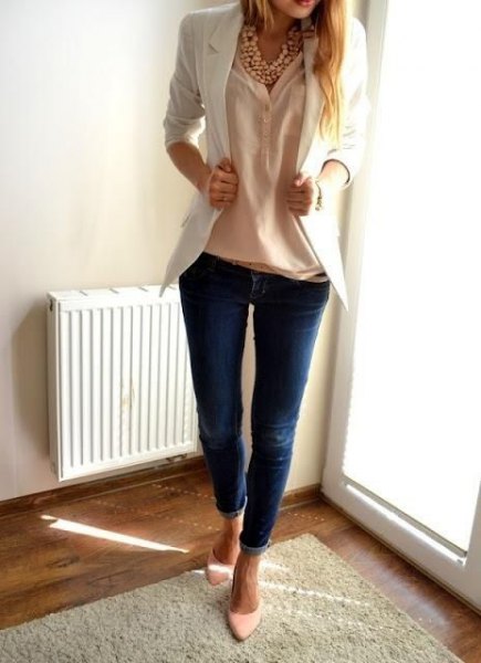 Cream-colored blouse with an ivory-colored blazer and dark blue skinny jeans