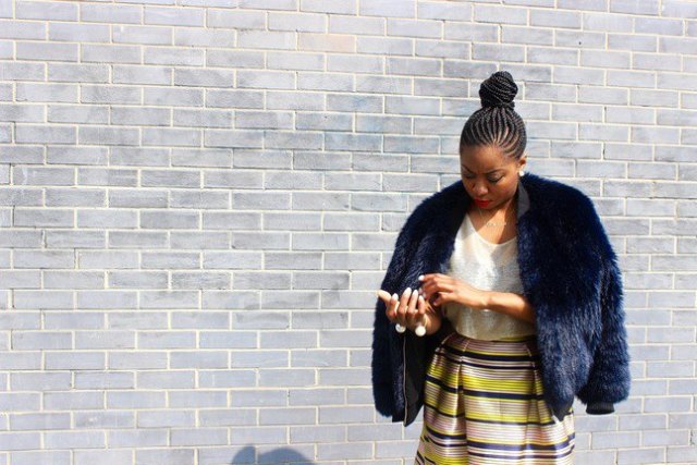 dark faux fur bomber jacket with a yellow and blue midi skirt with a high waist