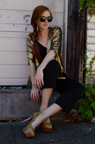 golden sequin jacket with black V-neck and matching shortened trousers