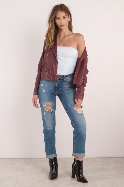 green bomber jacket with a tube top and ripped jeans with cuffs