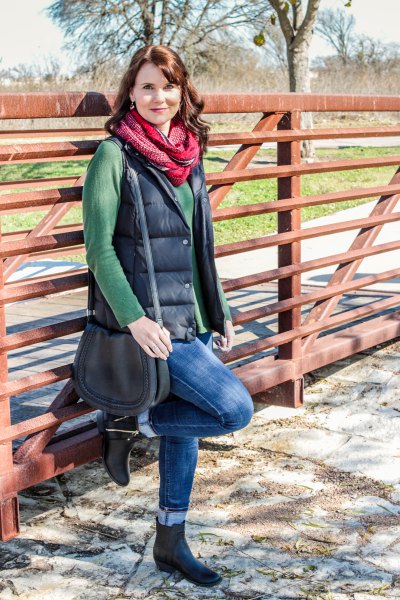 green sweater with waterfall neckline and black quilted vest
