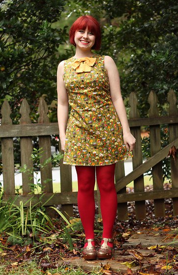 green sleeveless mini dress with floral pattern and red leggings