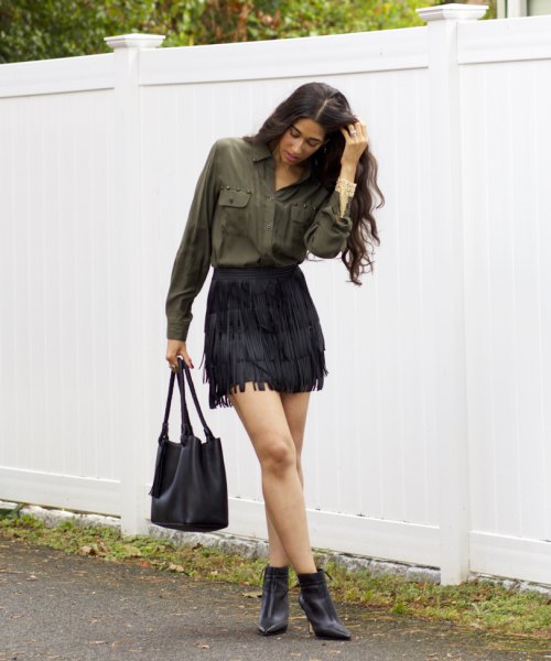 green shirt with button front and black mini skirt and boots