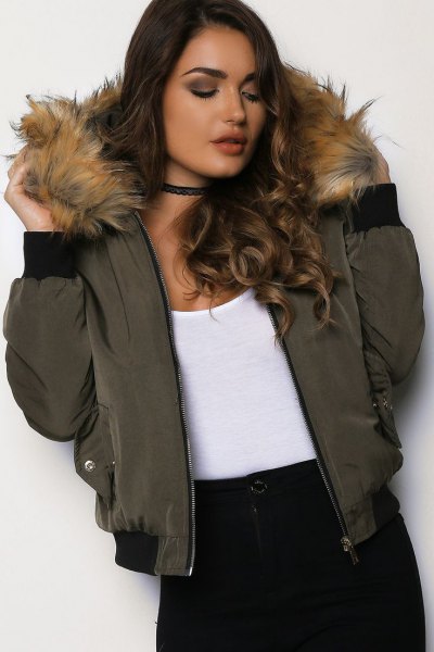 Bomber jacket with a green fur hood, white tank top and black collar