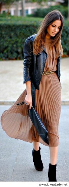 green midi dress made of pleated chiffon with black leather jacket