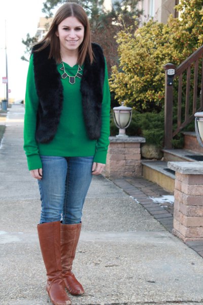 green sweater with black vest and knee-high boots made of camel suede