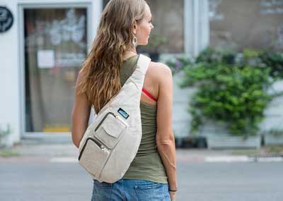 green tank top with ivory-colored shoulder bag and light blue jeans