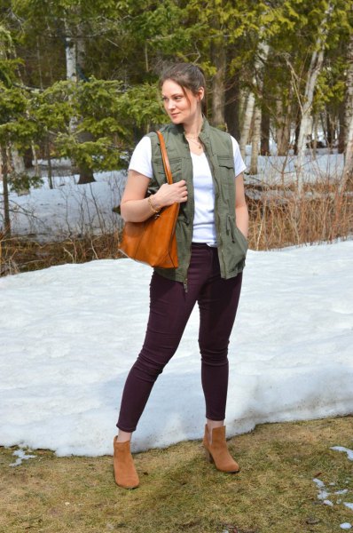 Green utility waistcoat with a white T-shirt and black jeans with a slim fit