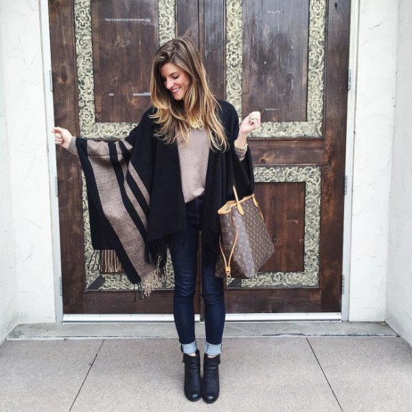 gray-black striped cape with dark blue skinny jeans with cuffs