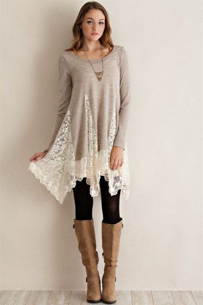 long tunic top made of gray and white lace with black leggings and knee-high boots