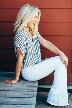 gray and white striped short-sleeved shirt with wide sleeves and jeans with a bell bottom