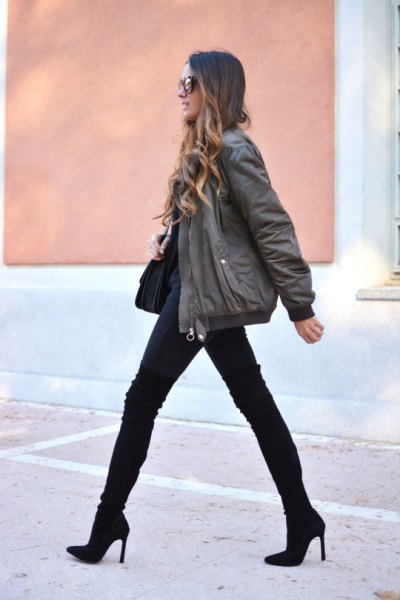 gray bomber jacket with black jeans and boots in the middle of the calf