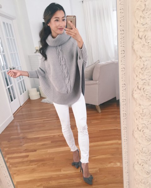 gray knitted sweater with wide sleeves and white slim fit jeans
