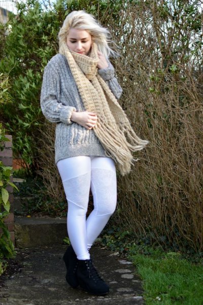 gray, coarse-grained knitted sweater with a blushing fringed scarf