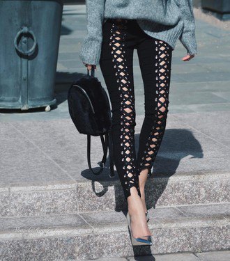 gray, coarsely knitted sweater with black leather pants with a lace neckline