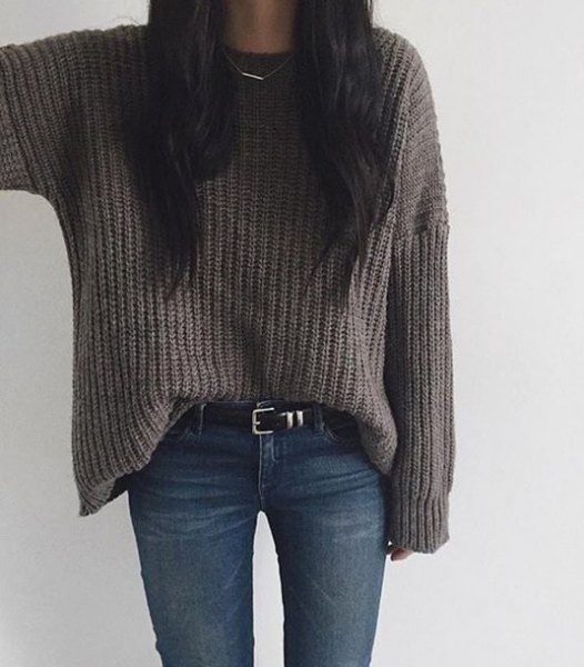 gray, coarsely knitted sweater with dark blue skinny jeans and belt