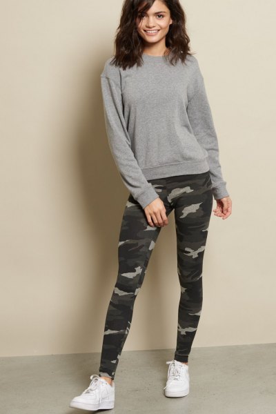 gray, chunky sweater with camouflage gaiters and white sneakers
