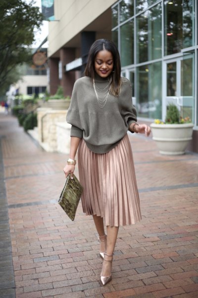 gray knitted sweater with round neckline and rose gold-colored pleated skirt