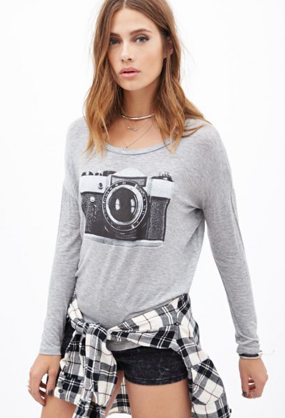 gray long-sleeved graphic t-shirt with black mini shorts and plaid shirt